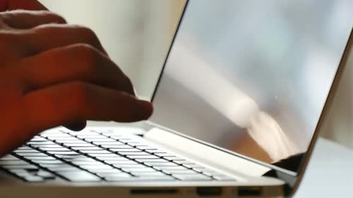 Homem digitando no laptop, local de trabalho moderno