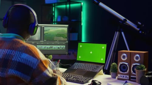 Video Editor Working at Desk with Green Screen