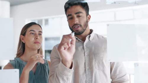 Творческие деловые люди, составление и планирование графика в команде для выполнения корпоративных задач на стекле