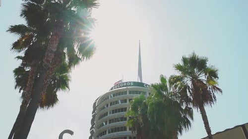 LA: Capitol Records building with palm trees in the foreground a clear blue skies with an American f