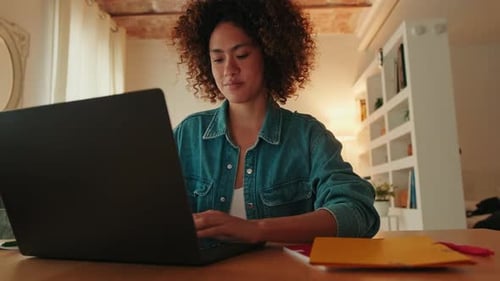 Young Adult Typing on Laptop at Desk