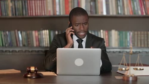 African Male Lawyer Talking on Phone with Client