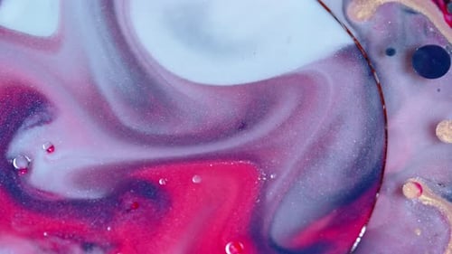 Vibrant swirls of pink and blue ink merging in water, creating abstract art