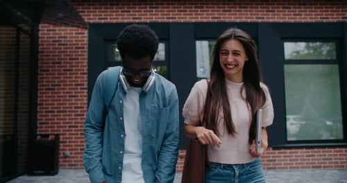 Cute Multiethnic Couple Walking Together Going Back Home After Studying at College or University