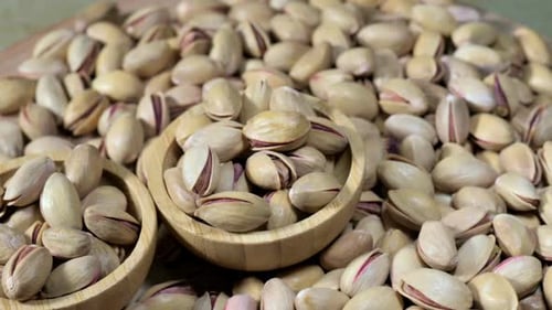 Pistachios Piled Around Two Wooden Bowls