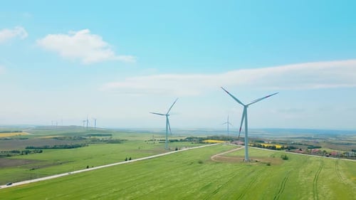 Wind Turbines Spinning in a Green Rural Field