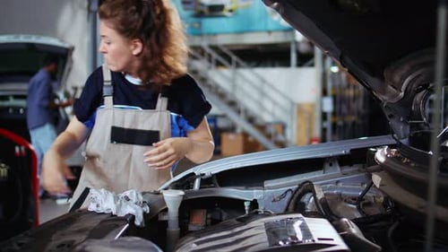 Serviceman in Garage Cleans Clients Car