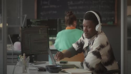 Software Developer Typing Code on Laptop and Smiling in Office