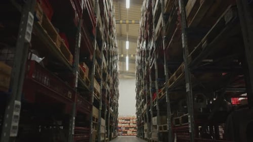 Inclinaison de hauts rayonnages remplis d'équipements dans l'allée d'une grande usine