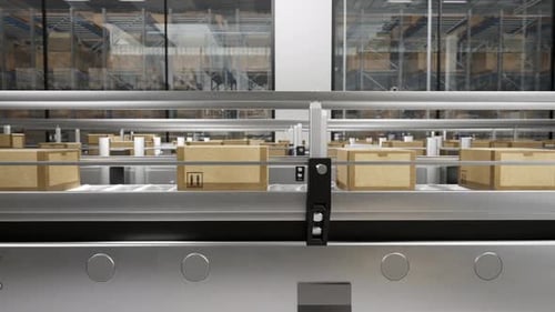 Packed Courier On Production Line Against Cardboard Boxes In Warehouse