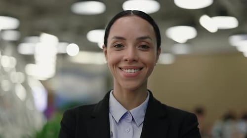 Elegant Young Teacher Posing to the Camera While Standing in the School Hall Wearing Formal Suit