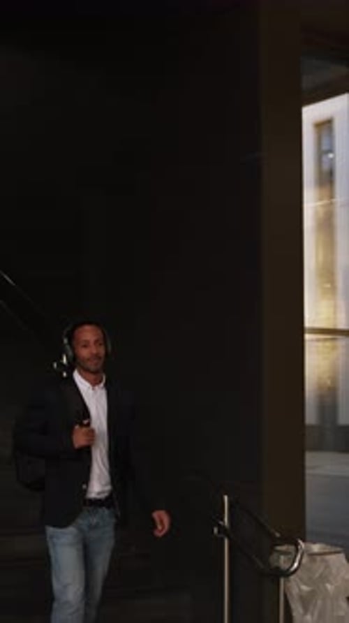 Businessman Walking Through Subway Station Wearing Headphones