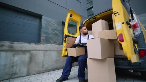 Delivery Man Checking Packages List on Clipboard