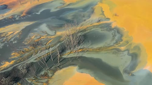 Aerial view of surreal toxic water stream from copper mine in decanting lake. Natural pattern