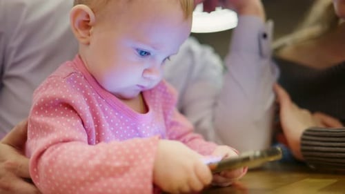 Baby Engrossed with Mobile Phone Screen Indoors