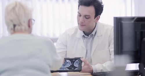 Doctor Consults With Patient, Showing Medical Scan