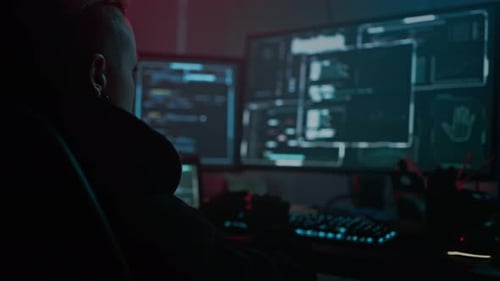 Person Coding at Computer Workstation at Night