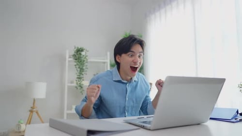 Excited Young Man Celebrates Success at Home