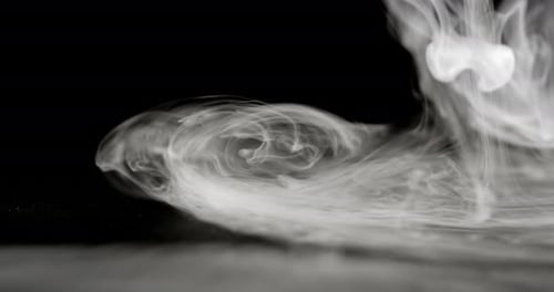 Close-Up Of Cascading Smoke Against A Dark Background