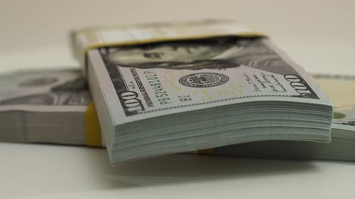 Stack of Bank Bundles with US Dollars on a White Background Closeup Shot of New Freshly Printed