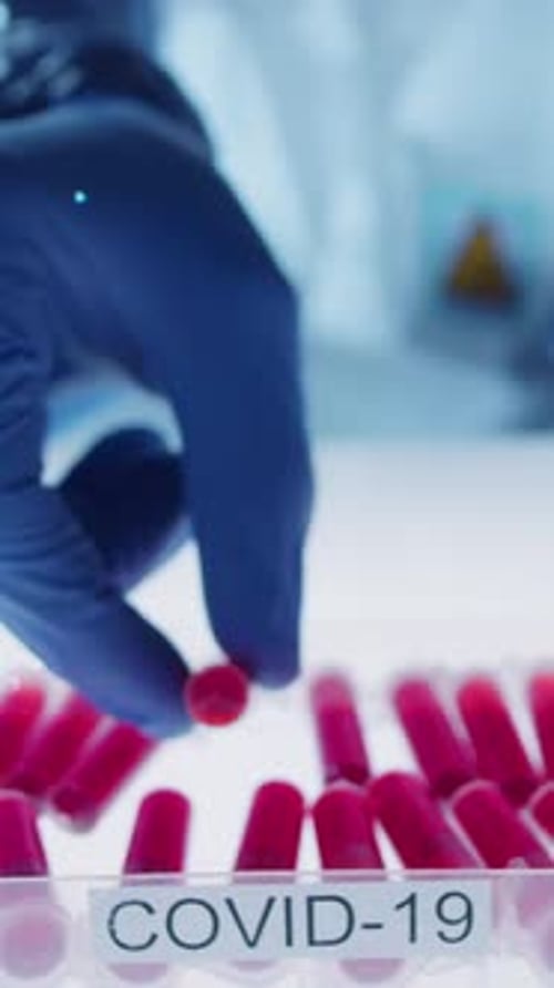 Doctor Examines Red Liquid in Test Tubes