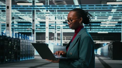 Portrait of Happy Data Center System Administrator Using Laptop Software