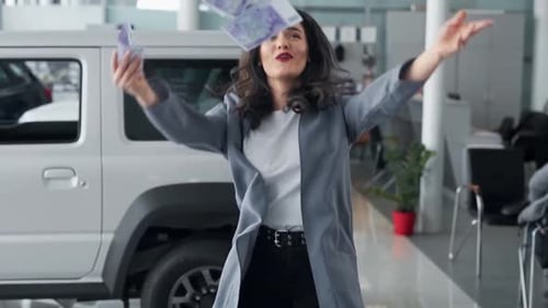Beautiful woman scattering money in a car dealership by car