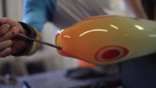 Glassblower Shaping Molten Glass Art in Workshop