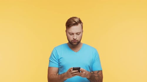 Man Using Smartphone on Yellow Background