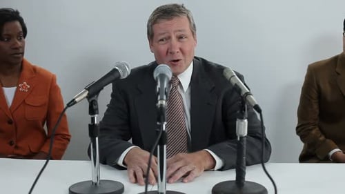 Panel of professionals at a conference table speaking