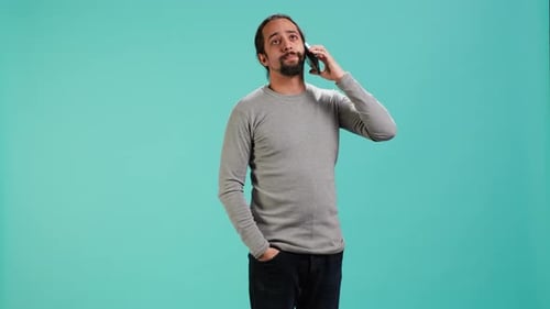 Young Man Talking on Mobile Phone in Studio