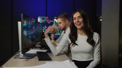 Excited Woman Holding Money at Trading Desk