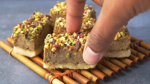 Deliciously Crafted Pistachio and Nut Dessert Squares Beautifully Presented on a Bamboo Mat