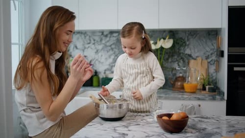Woman and Child Baking Together in Modern Kitchen