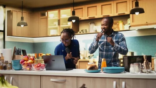 Cheerful Adults Sing Karaoke in Modern Kitchen
