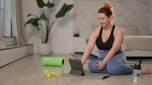 Woman Using Tablet Before Exercise At Home