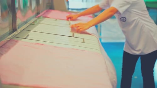 Worker Loading Conveyor Belt in Laundry Facility