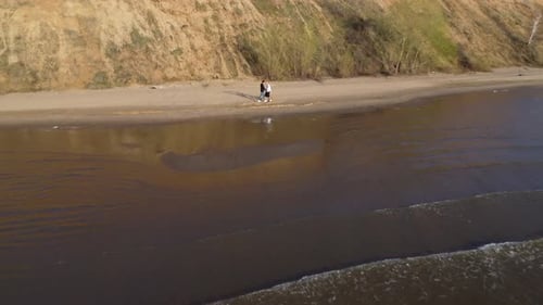 A Couple Leisurely Walking Together Along a Picturesque and Serene Beach During Sunset Hours