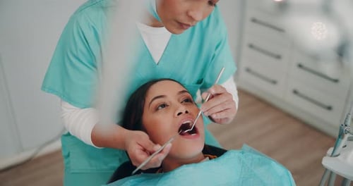 Dentist Examining Patient in Dental Clinic