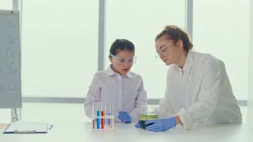 Child Learning Science with Young Adult in Lab