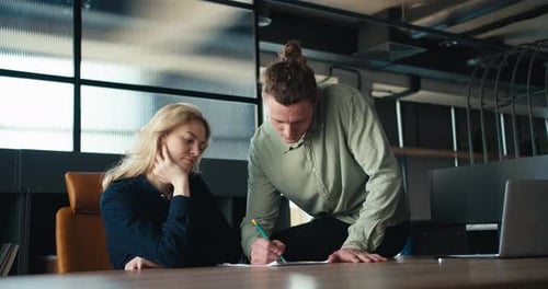 Communication efficace Un homme brun expliquant à une femme blonde au bureau