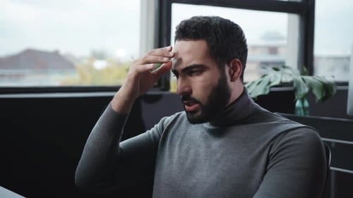 Un professionnel concentré qui travaille assidûment sur son clavier dans un environnement de bureau moderne