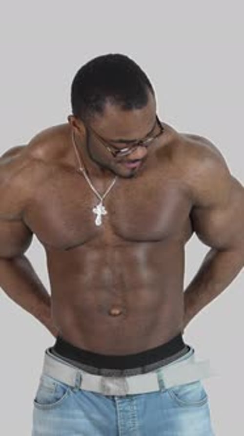 Muscular Man Posing Shirtless, Jeans and Glasses