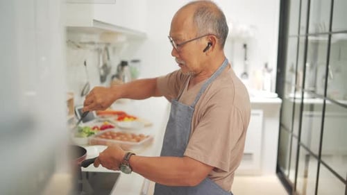 Senior Adult Cooking Food in Bright Kitchen
