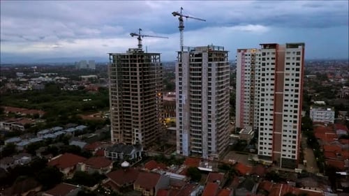 4K Aerial shot of the building in the middle of construction. Drone flying near the unfinished build