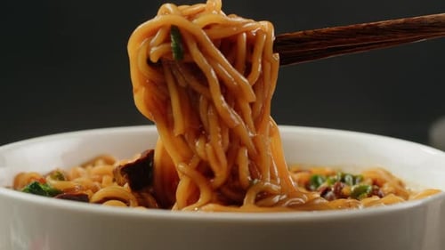 Chopsticks Lifting Delicious Noodles in Close Up