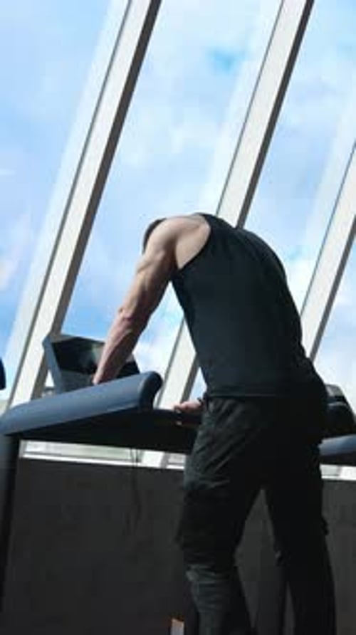 Fitness man running on treadmill. Young man running on the treadmill in the fitness studio