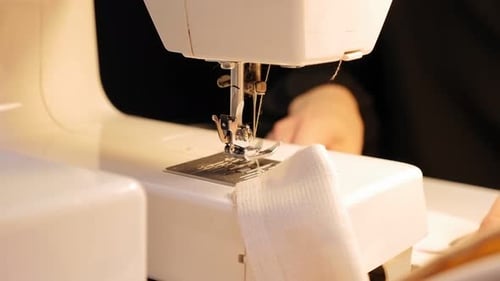 The Dressmaker in the Atelier Sews a Dress Made of Fabric on a Sewing Machine