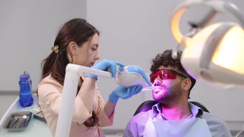 Dentist Performing Teeth Whitening Procedure on Patient