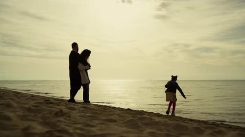 Parents Child Relaxing Together on Beach Vacation. Silhouette of Family Having Fun